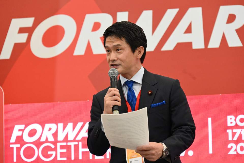 国際会議の会場でスピーチする小川代表